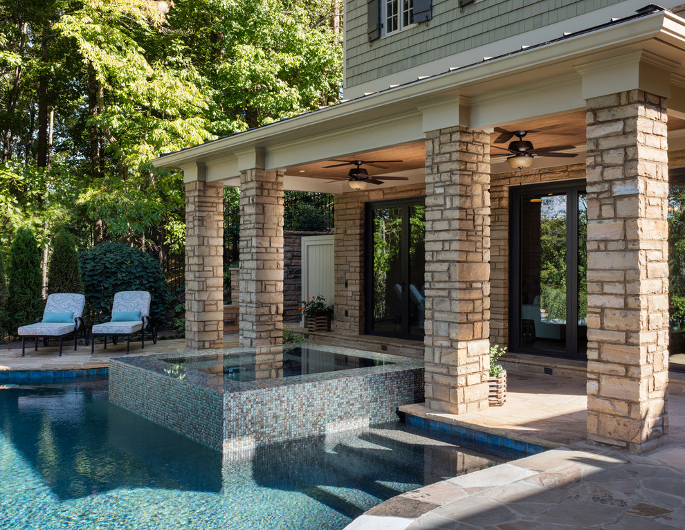 Ejemplo de casa de la piscina y piscina infinita tradicional extra grande a medida en patio trasero con adoquines de ladrillo