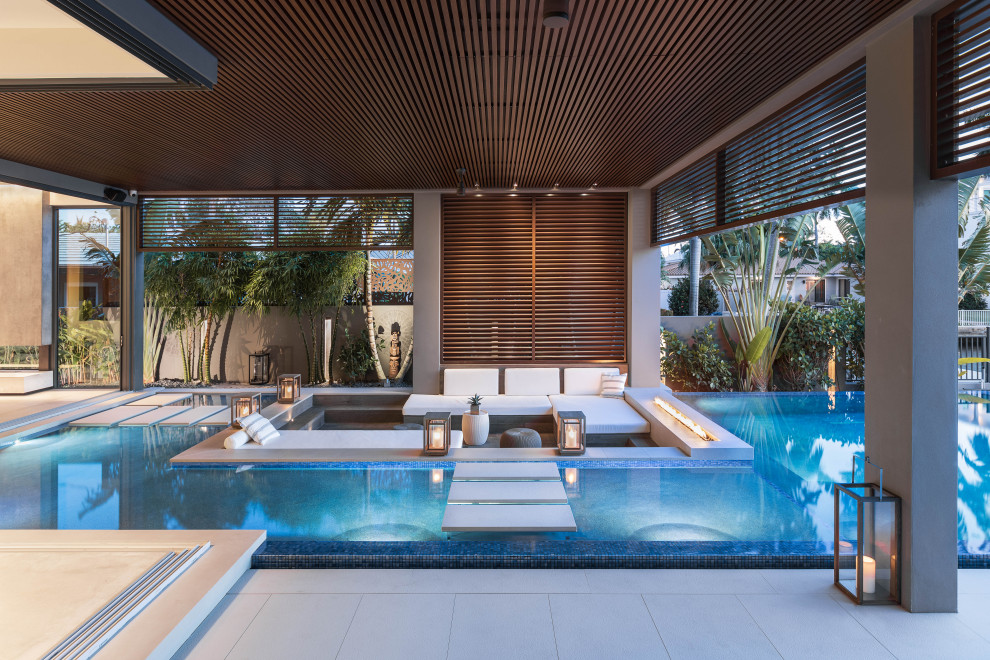 Pool - huge modern backyard custom-shaped infinity pool idea in Miami with decking
