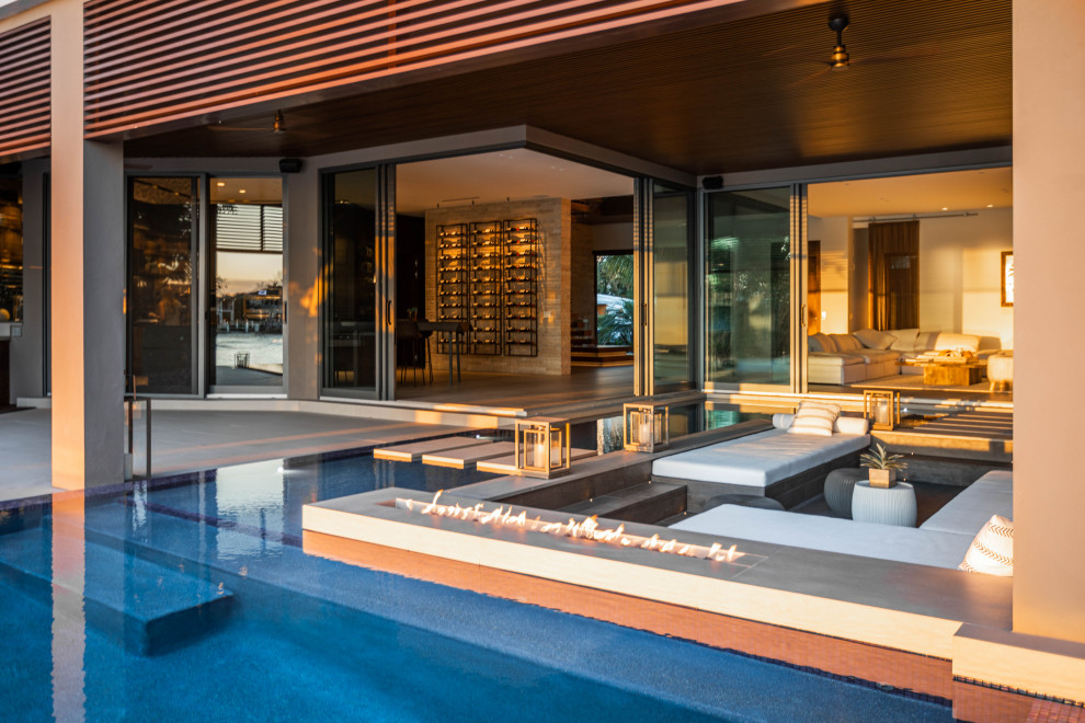 Geräumiger Moderner Infinity-Pool hinter dem Haus in individueller Form mit Dielen in Miami