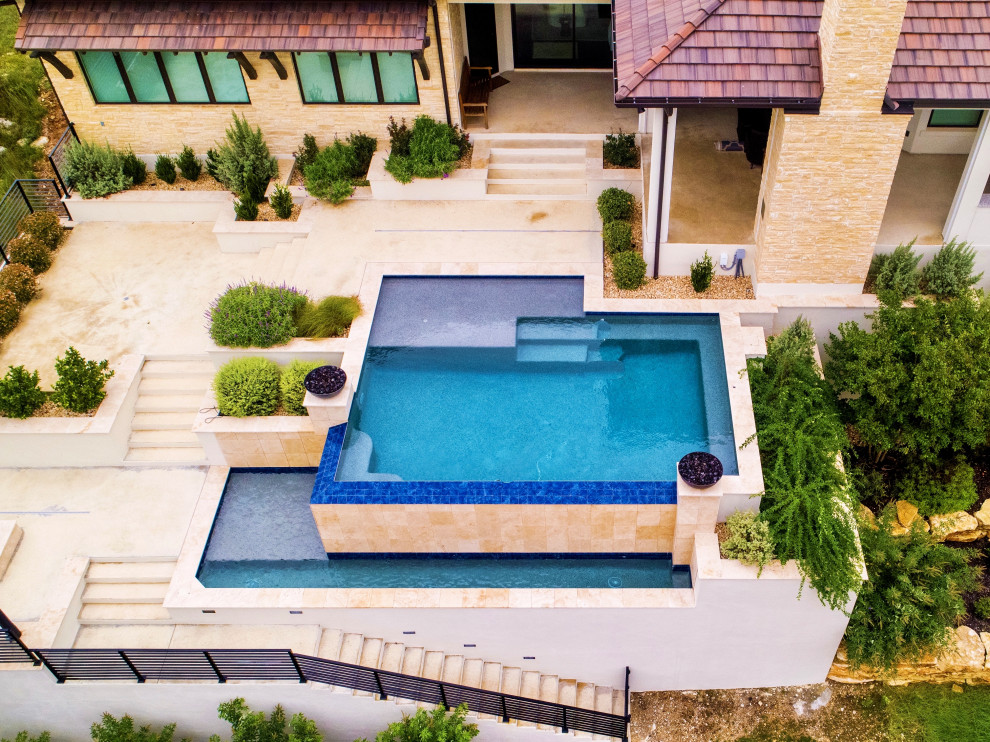 На фото: огромный прямоугольный бассейн-инфинити на заднем дворе в стиле модернизм с перегородкой для приватности и покрытием из бетонных плит