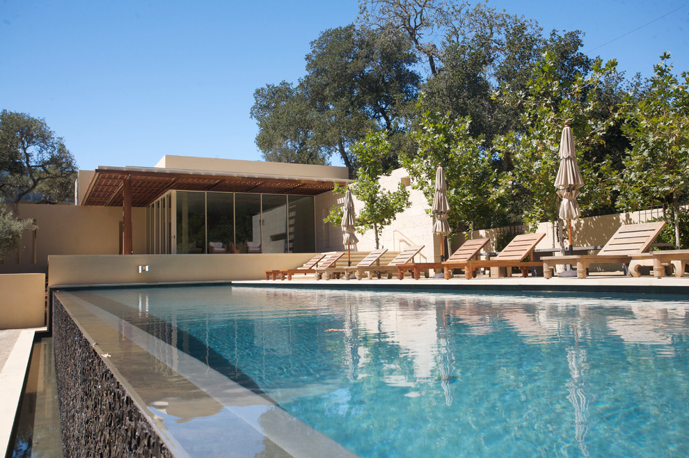Example of a large trendy backyard stone and rectangular infinity pool design in San Francisco