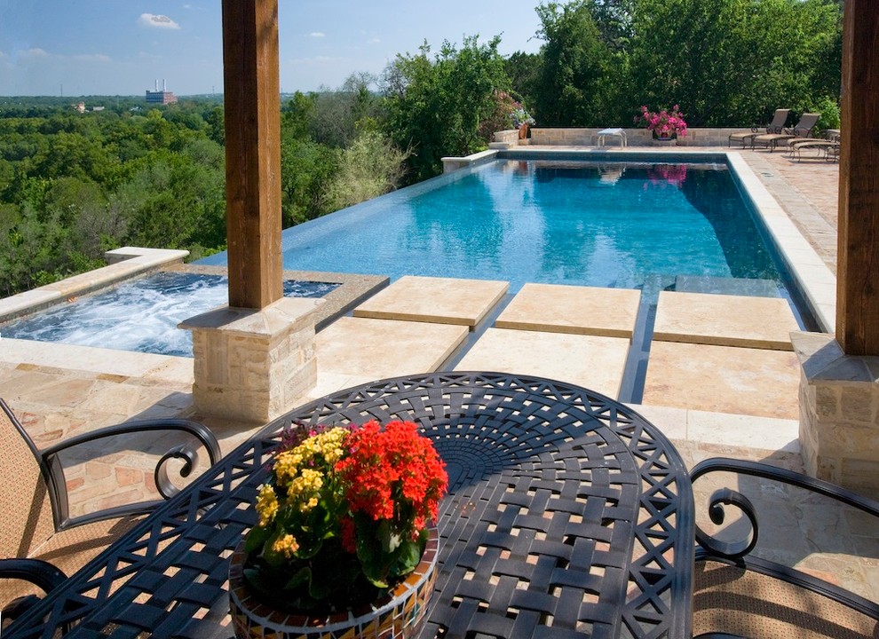 Modelo de piscinas y jacuzzis infinitos clásicos de tamaño medio rectangulares en patio trasero con adoquines de ladrillo