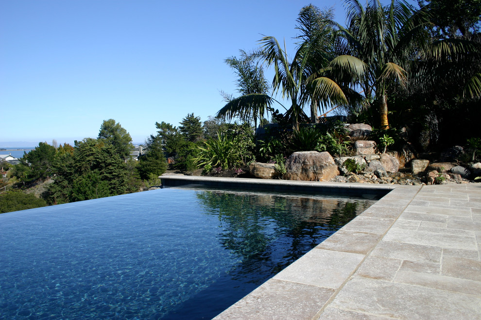 Ispirazione per una piscina a sfioro infinito tropicale
