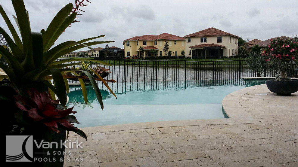 Foto de piscina con fuente infinita contemporánea de tamaño medio a medida en patio trasero con adoquines de piedra natural