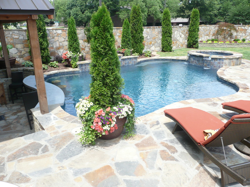 Inspiration for a medium sized contemporary back custom shaped lengths hot tub in Little Rock with natural stone paving.