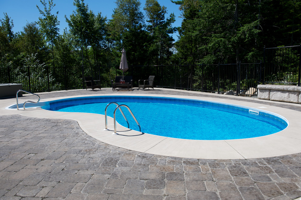 Inspiration for a mid-sized timeless backyard stone and kidney-shaped pool remodel in Other