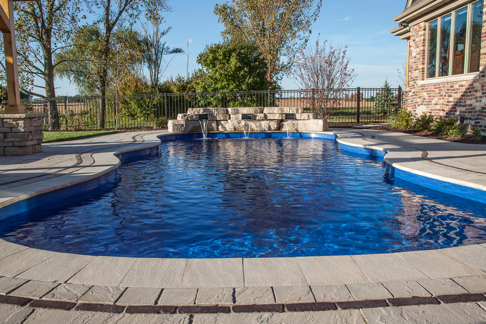 Inspiration for a mid-sized modern backyard stone and custom-shaped natural pool fountain remodel in Chicago