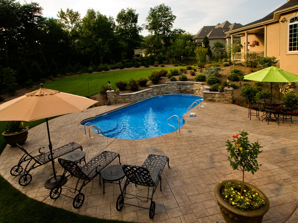 Pool - mid-sized traditional backyard concrete paver and custom-shaped lap pool idea in Other