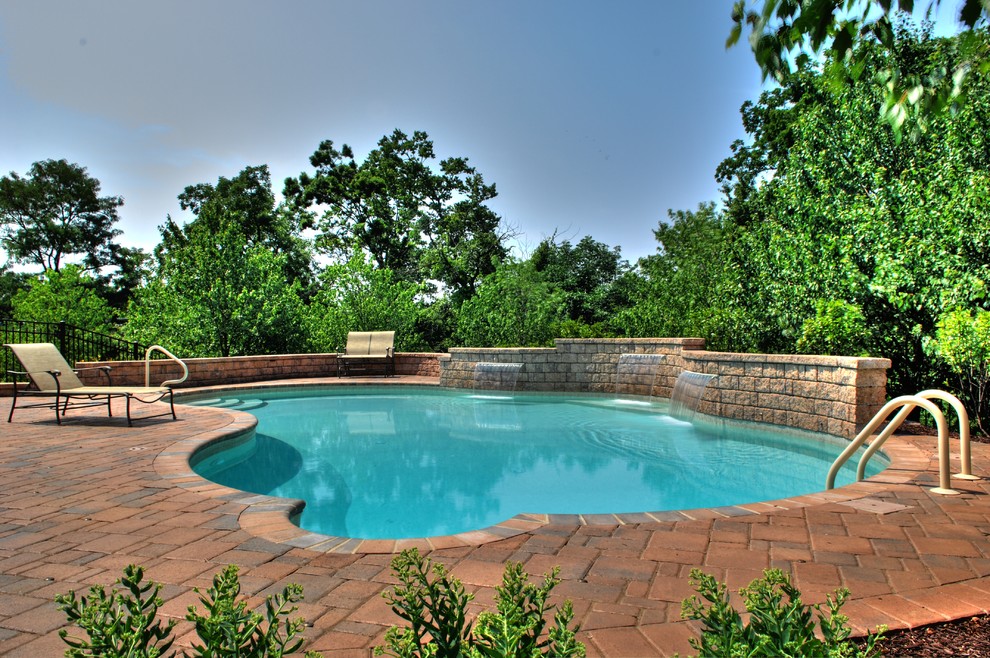 Immagine di una piscina monocorsia mediterranea personalizzata di medie dimensioni e dietro casa con fontane e pavimentazioni in cemento