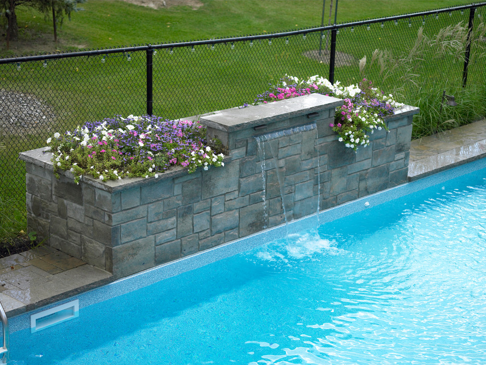 Imagen de piscina con fuente natural minimalista pequeña a medida en patio trasero con adoquines de ladrillo
