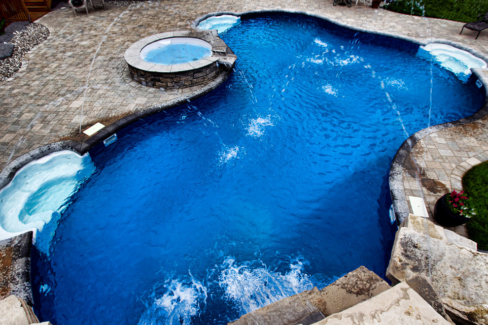 Inground pool with fountains, waterfall, and built in spa Modern