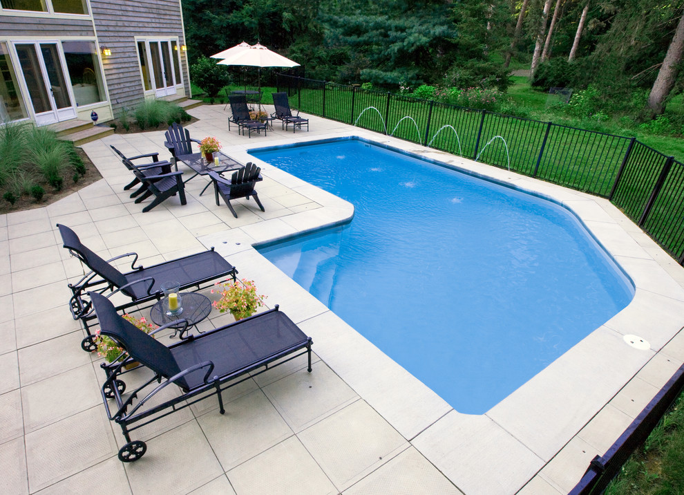 Ispirazione per una piscina classica a "L" di medie dimensioni e dietro casa con fontane e pavimentazioni in cemento