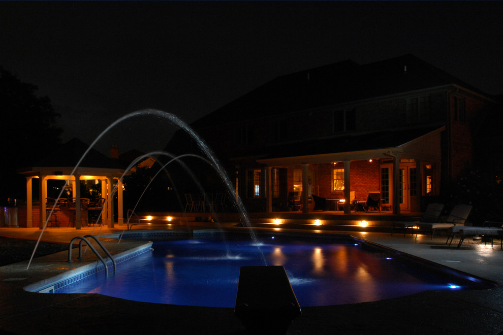 Foto di una piscina monocorsia tradizionale di medie dimensioni e dietro casa con fontane
