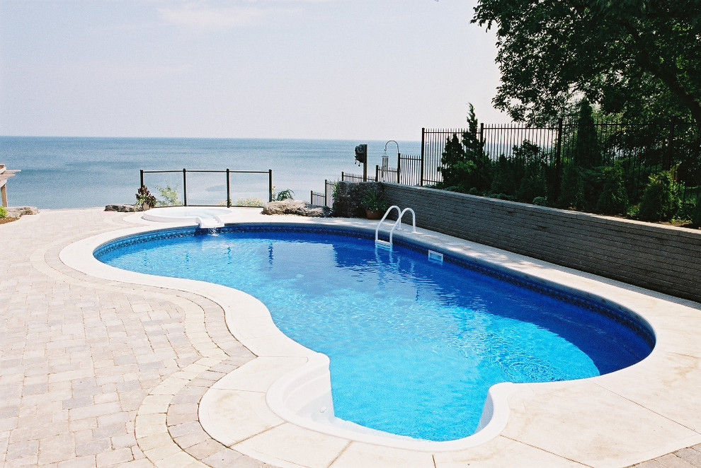 Großer Klassischer Schwimmteich hinter dem Haus mit Wasserspiel und Pflastersteinen in Toronto