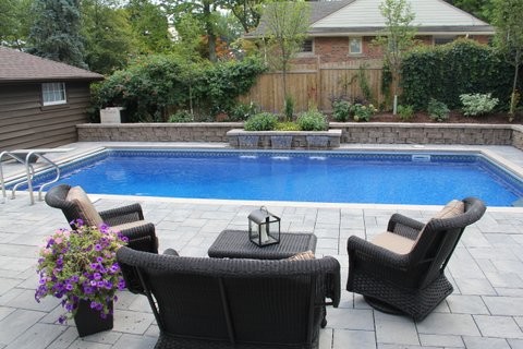 Ejemplo de piscina con fuente minimalista de tamaño medio rectangular en patio trasero
