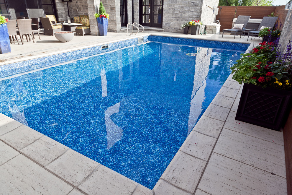 Diseño de piscina minimalista de tamaño medio rectangular en patio lateral con adoquines de piedra natural