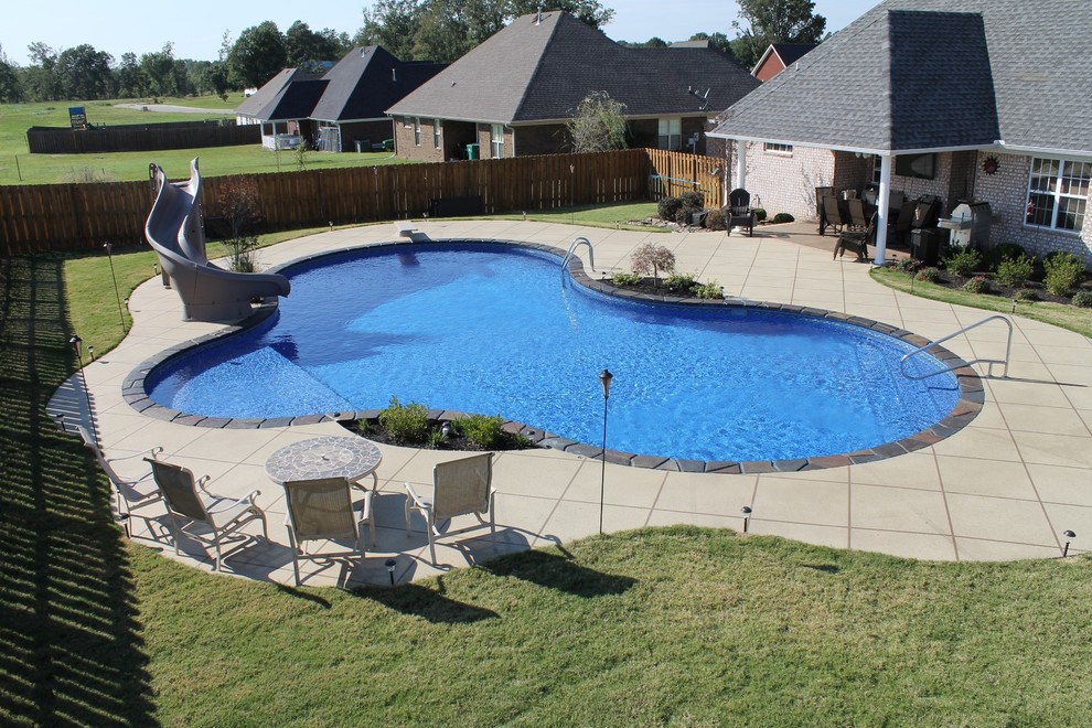 Inspiration för en stor amerikansk anpassad pool på baksidan av huset, med betongplatta
