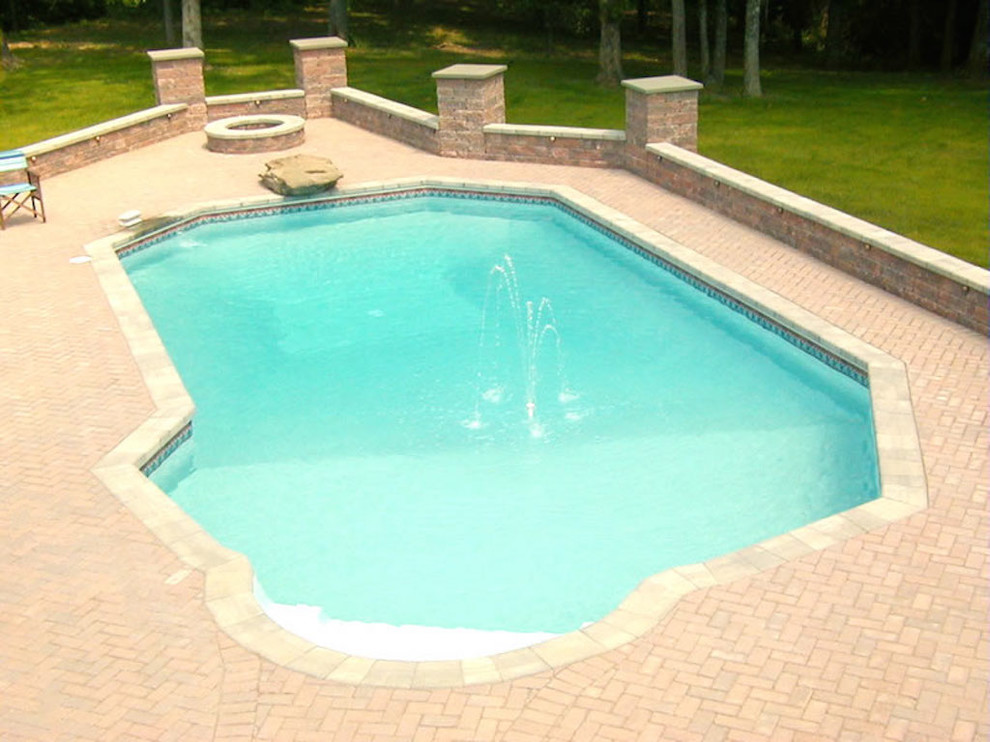 Imagen de piscina con fuente alargada minimalista de tamaño medio a medida en patio trasero con adoquines de ladrillo