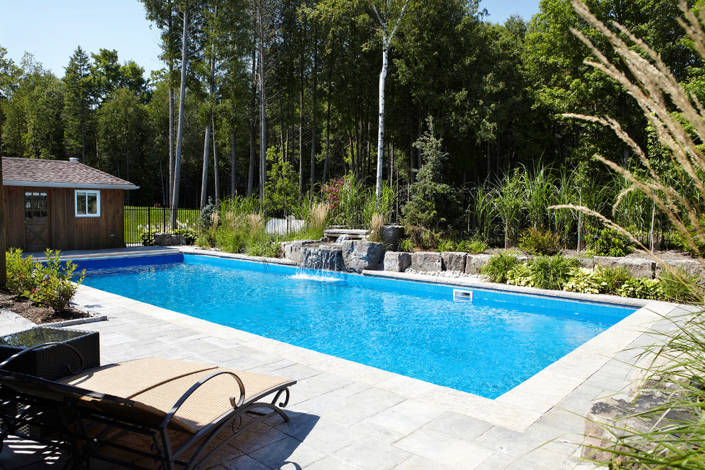 Idee per una grande piscina monocorsia design rettangolare dietro casa con fontane e pavimentazioni in mattoni