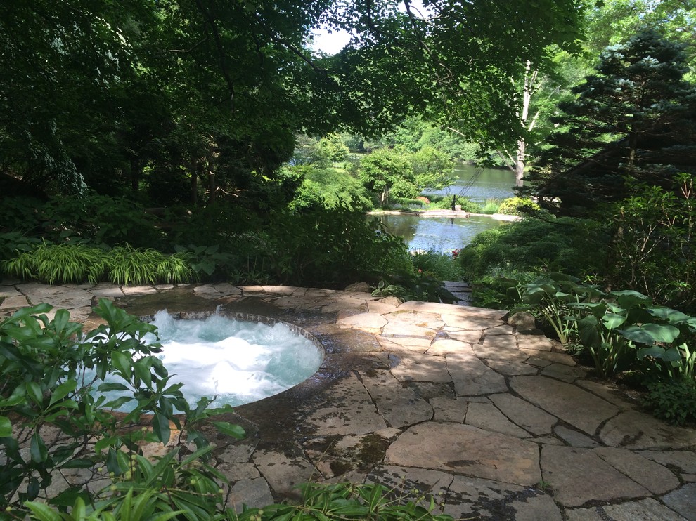 Immagine di una piccola piscina naturale tradizionale rotonda nel cortile laterale con pavimentazioni in pietra naturale