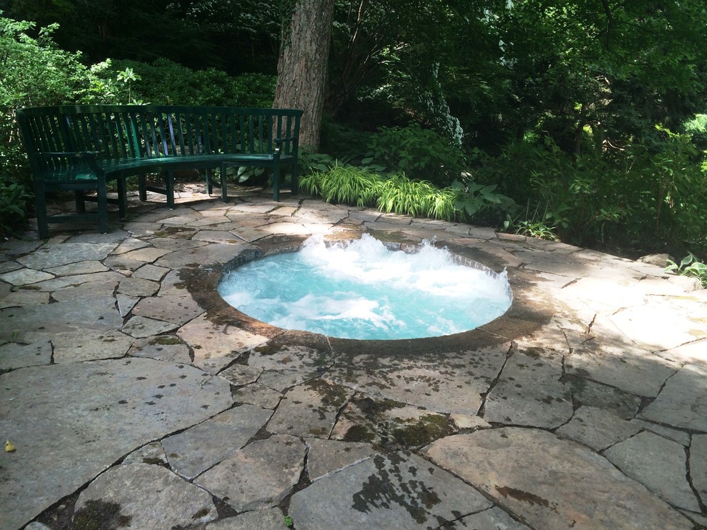 Inspiration for a small timeless side yard stone and round hot tub remodel in New York