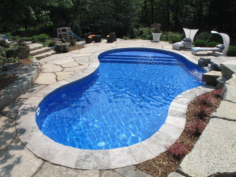 Cette photo montre une piscine arrière tendance de taille moyenne et sur mesure avec des pavés en pierre naturelle.