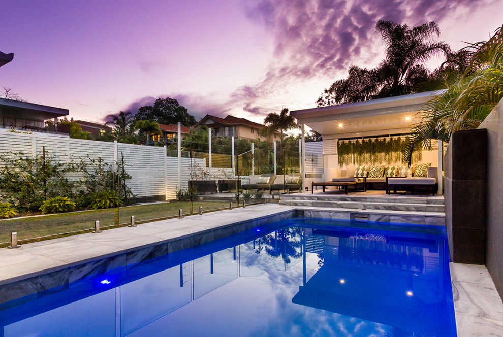 Esempio di una piscina monocorsia design rettangolare di medie dimensioni e dietro casa con fontane e pavimentazioni in pietra naturale