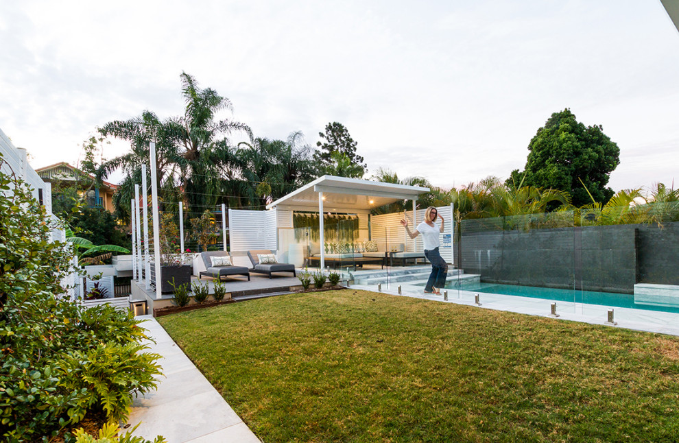Großes Modernes Sportbecken hinter dem Haus in rechteckiger Form mit Wasserspiel und Natursteinplatten in Brisbane