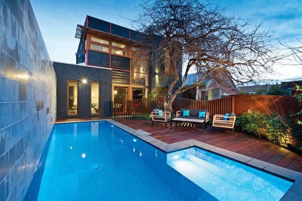Photo of a contemporary rectangular lengths swimming pool in Sydney with decking and fencing.