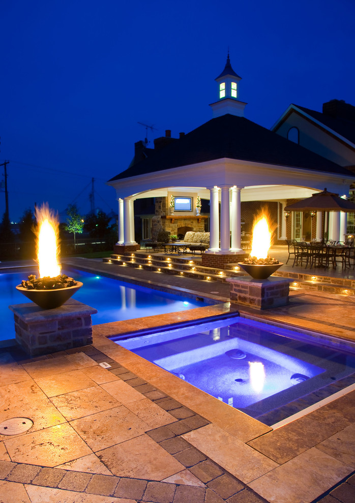 This is an example of a back rectangular hot tub with concrete paving.