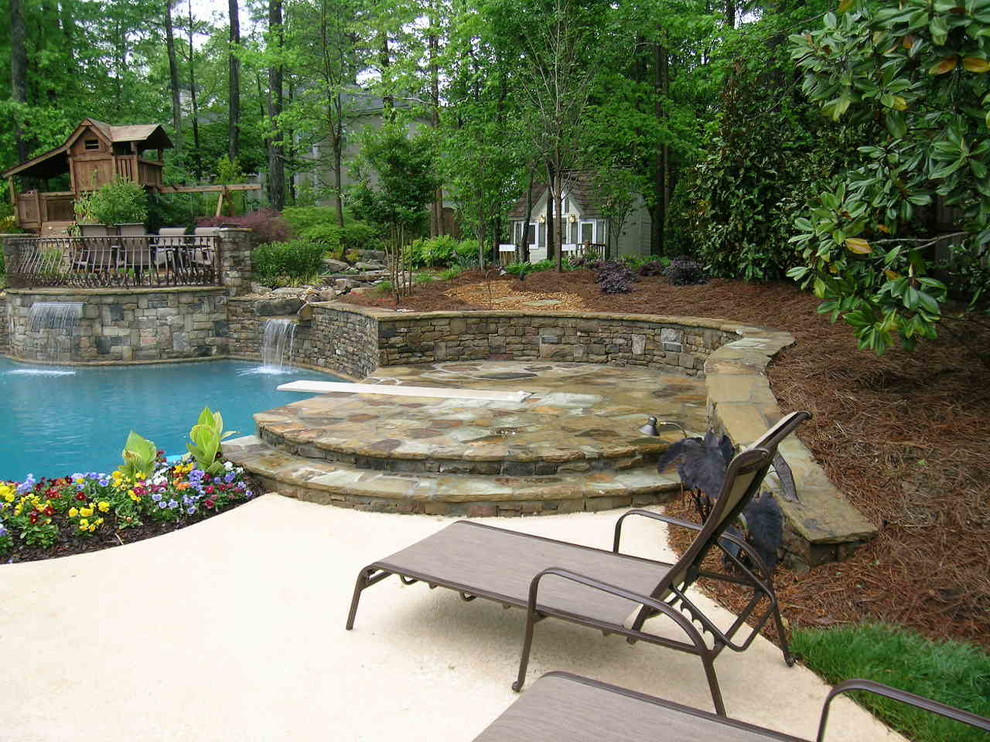 Esempio di una grande piscina naturale classica personalizzata dietro casa con fontane e pavimentazioni in pietra naturale