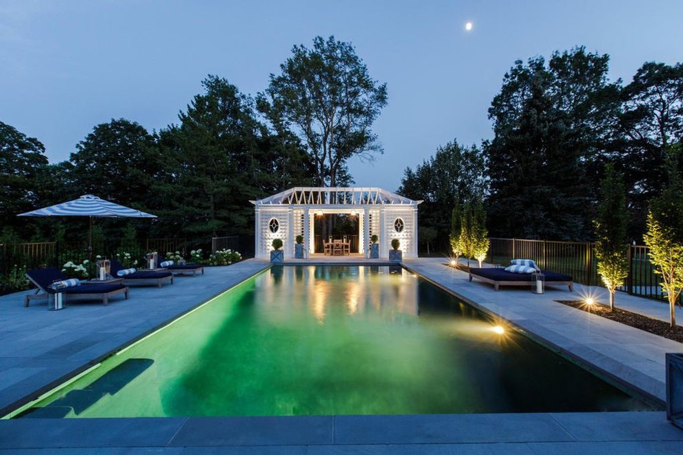 Immagine di una grande piscina monocorsia country rettangolare dietro casa con una dépendance a bordo piscina e graniglia di granito