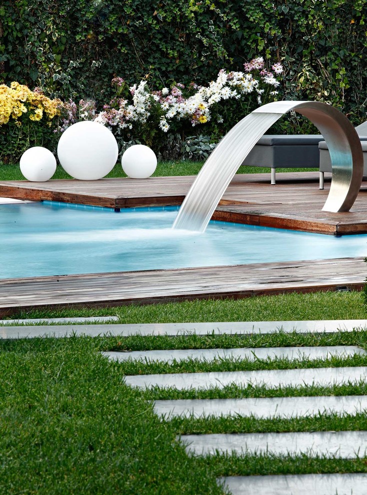 Idée de décoration pour une piscine design avec une terrasse en bois.