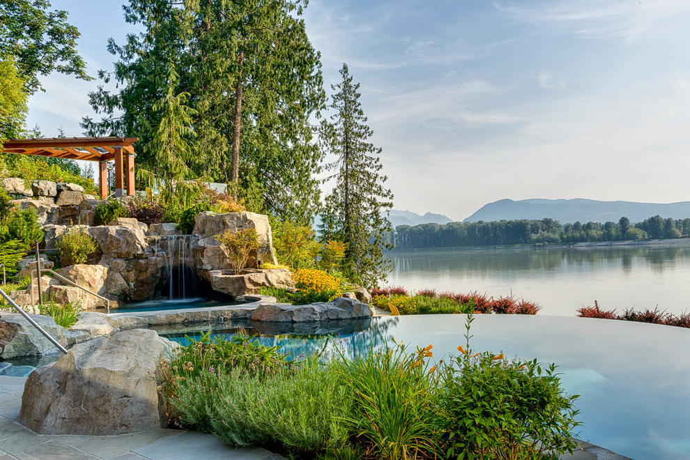 Inspiration for a mid-sized rustic stone and custom-shaped infinity pool fountain remodel in Vancouver