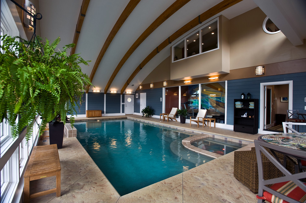 Foto di un'ampia piscina coperta monocorsia minimal rettangolare con una vasca idromassaggio e cemento stampato