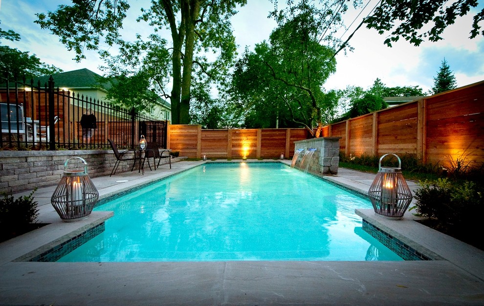 Cette photo montre une piscine naturelle et arrière moderne de taille moyenne et rectangle avec un point d'eau et des pavés en béton.
