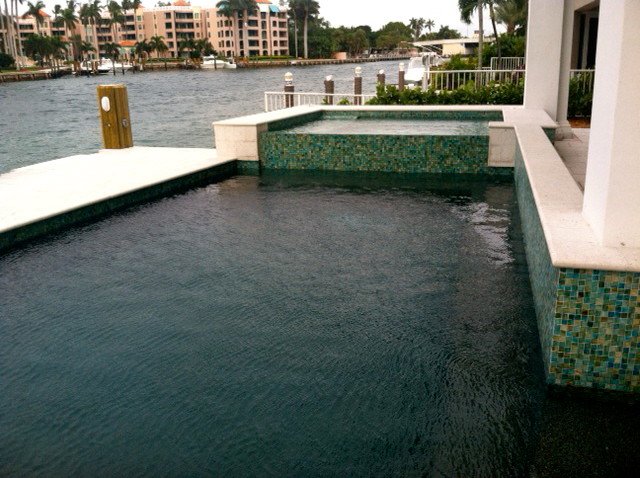 Foto di una grande piscina monocorsia eclettica rettangolare dietro casa con una vasca idromassaggio e pavimentazioni in pietra naturale