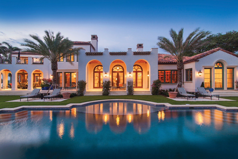 Photo of a large mediterranean back custom shaped swimming pool in Tampa with a water feature.