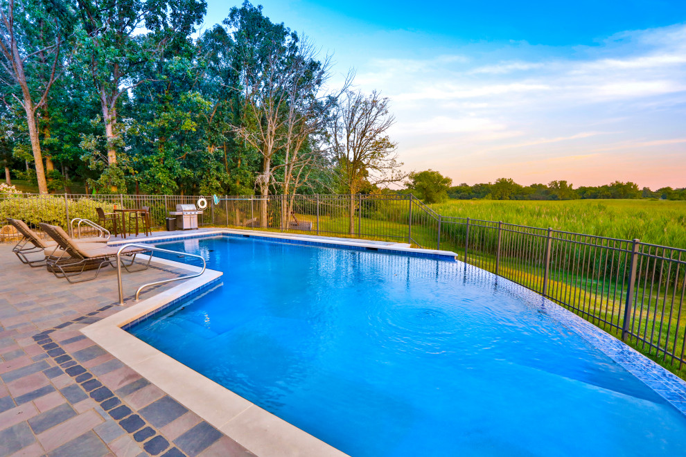 Foto di una piscina a sfioro infinito tradizionale personalizzata di medie dimensioni e dietro casa con paesaggistica bordo piscina e pavimentazioni in cemento