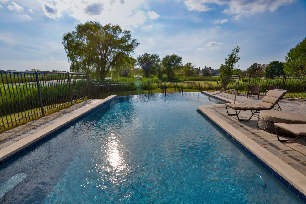 Ispirazione per una piscina a sfioro infinito classica personalizzata di medie dimensioni e dietro casa con paesaggistica bordo piscina e pavimentazioni in cemento