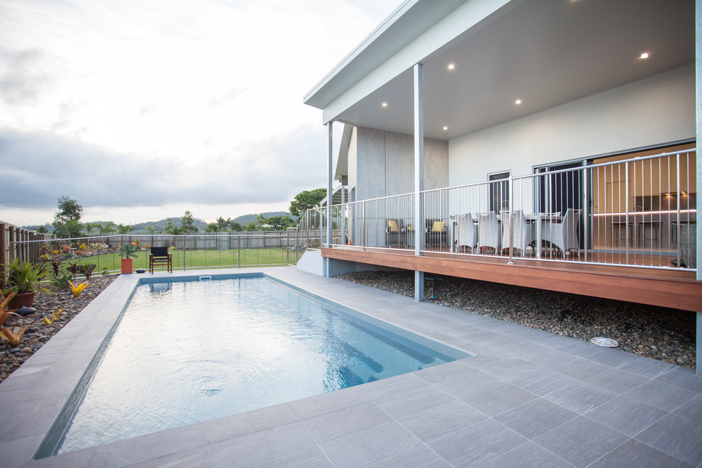 Foto di una piscina monocorsia design rettangolare di medie dimensioni e dietro casa con piastrelle e paesaggistica bordo piscina
