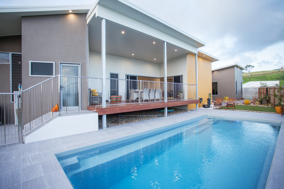 Mittelgroßes, Gefliestes Modernes Sportbecken hinter dem Haus in rechteckiger Form mit Pool-Gartenbau in Sonstige