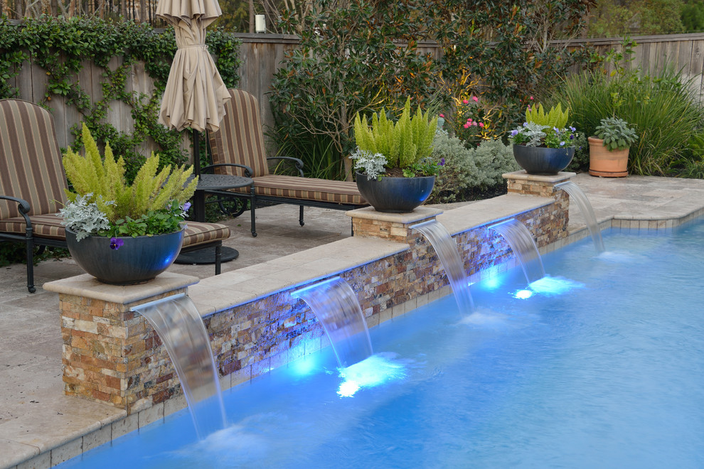 На фото: большой естественный, прямоугольный бассейн на заднем дворе в стиле неоклассика (современная классика) с джакузи и покрытием из каменной брусчатки