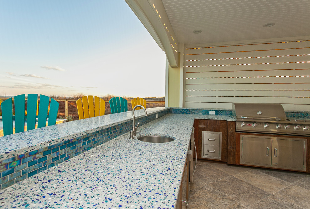 Idee per un'ampia piscina monocorsia stile marino a "L" dietro casa con una dépendance a bordo piscina e pavimentazioni in pietra naturale
