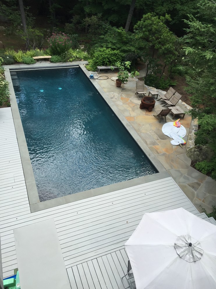 Idee per una piscina design rettangolare di medie dimensioni e dietro casa con pavimentazioni in pietra naturale