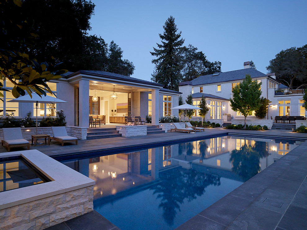 Foto di una piscina monocorsia design rettangolare di medie dimensioni e dietro casa con una vasca idromassaggio e piastrelle