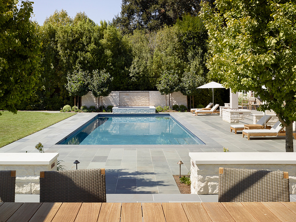 Esempio di una piscina monocorsia design rettangolare di medie dimensioni e dietro casa con una vasca idromassaggio e piastrelle