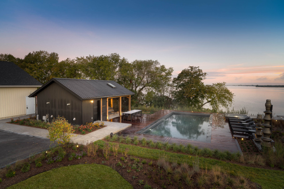 Esempio di una grande piscina minimalista rettangolare nel cortile laterale con paesaggistica bordo piscina e pedane