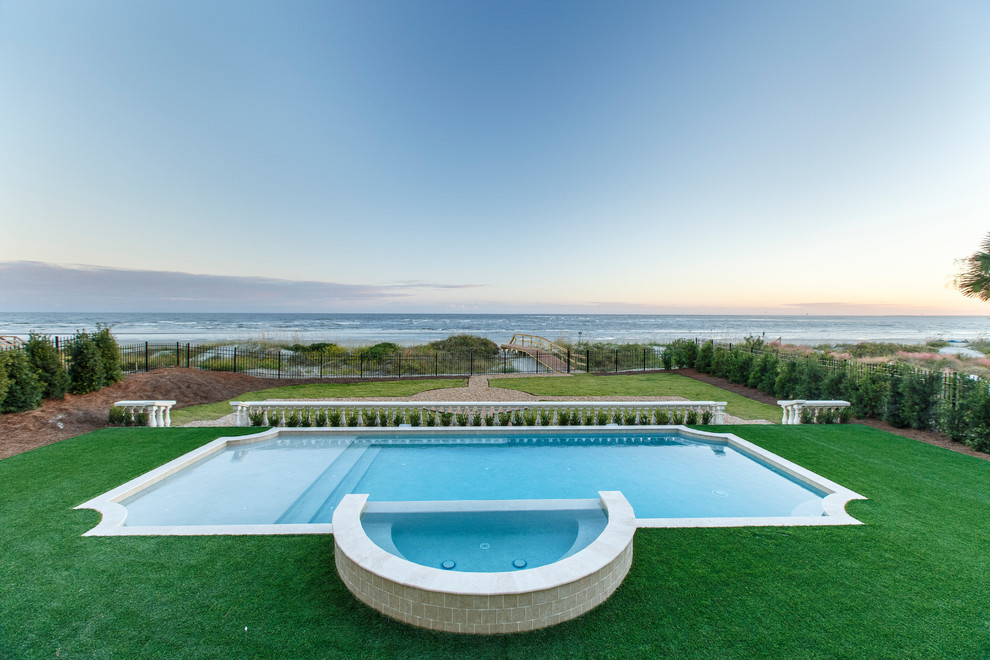 Aménagement d'une grande piscine arrière méditerranéenne rectangle avec un bain bouillonnant et des pavés en pierre naturelle.