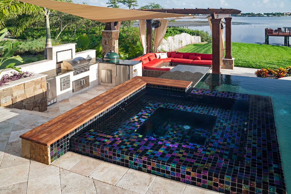 Idee per una grande piscina a sfioro infinito contemporanea personalizzata dietro casa con una dépendance a bordo piscina e pavimentazioni in pietra naturale